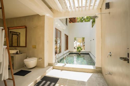 a bathroom with a pool in the middle of a house at Hibiscus Beach Hotel & Villas in Kalutara