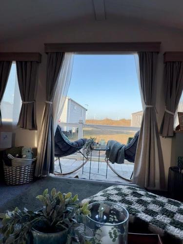 a living room with a large window with a view of a field at Luxury Caravan, On the beach in Redcar