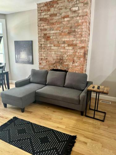 a living room with a couch and a brick wall at Jungle House Columbus Downtown Free Parking Sleeps 8 - Near Convention Center & Nationwide Arena - 2BR Short North Luxury Home - Over 5,800 Five Star Stays in Columbus