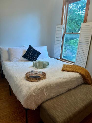 a bed with a tray on top of it with a window at Jungle House Luxury Stays - Columbus Downtown Short North in Columbus
