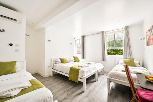 a bedroom with two beds and a window at City London Hotel in London