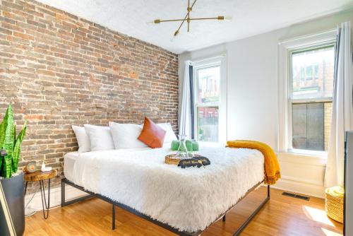 a bed in a room with a brick wall at Jungle House Luxury Homes - Columbus Downtown Short North - Walk to Convention Center & Nationwide Arena - Sleeps up to 8 - Free Parking - Over 5,800 Five Stars in Columbus