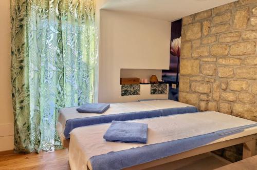 deux lits dans une chambre avec un mur en pierre dans l'établissement Hotel Joli, à Saint-Marin
