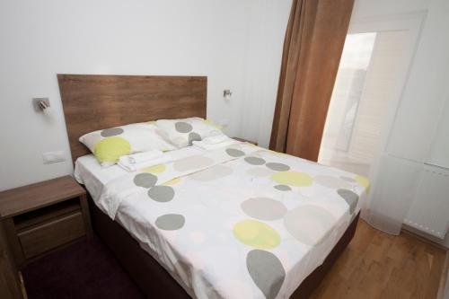 a bedroom with a bed with a polka dot blanket at Apartment Butterfly in Osijek