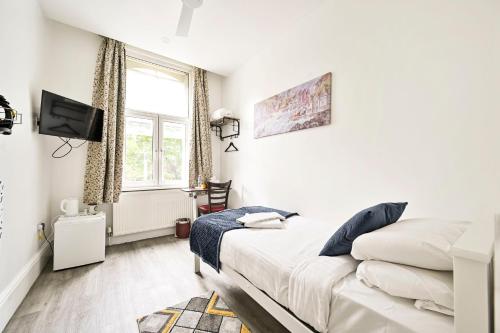 a bedroom with a bed and a tv and a window at City London Hotel in London