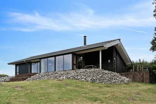 a house on a hill with a pile of rocks at Seaside Cottage At Bønnerup Strand in Glesborg