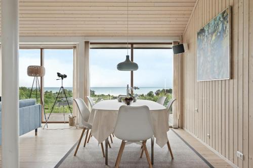 a dining room with a table and chairs and a view of the ocean at Seaside Cottage At Bønnerup Strand in Glesborg