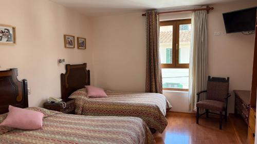a hotel room with two beds and a window at Casa Elena in Cusco