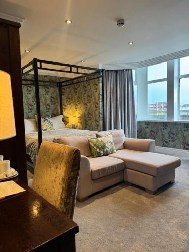 a bedroom with a bed and a couch and a table at Number One South Beach in Blackpool