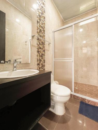 a bathroom with a toilet and a sink and a shower at Kindia Park Hotel in La Esmeralda