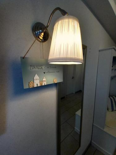 a lamp with a sign hanging from a wall at Ferienwohnungen Seeglück in Senftenberg
