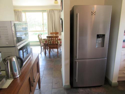 a kitchen with a stainless steel refrigerator and a dining room at Maslin Beach House in Maslin Beach