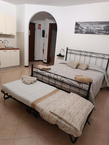 two beds sitting in a room with a kitchen at AleGio Home in Zelo Buon Persico