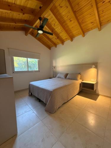a bedroom with a bed and a ceiling fan at Treffen Cabañas in Villa General Belgrano