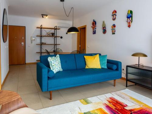 a blue couch sitting in a living room at Central Caldas w/ AC & Fast Net in Caldas da Rainha
