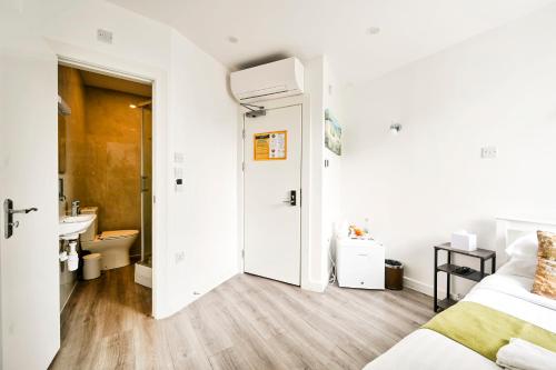 a bedroom with a bed and a bathroom with a sink at City London Hotel in London