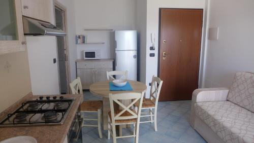 a small kitchen with a table and a couch at Residence Buganvillea in Alghero