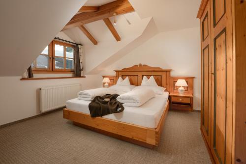 a bedroom with a bed with white sheets and pillows at Brandhof in Ramsau am Dachstein
