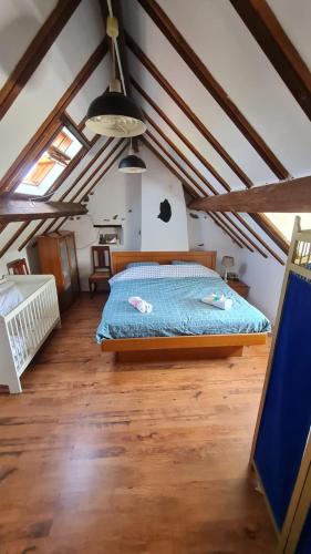 a bedroom with a bed in a room with wooden floors at Ciel Etoillè in Saint-Bonnet-de-Four