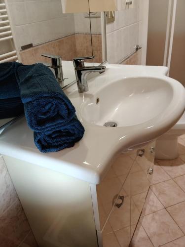 a white bathroom sink with a blue towel on it at Maria Luisa Home in Poggibonsi
