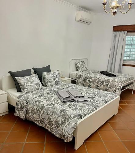 a bedroom with two beds and a couch at Casa do Cabo Alto in Areal