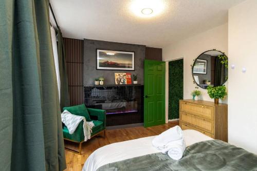 a bedroom with a green door and a green chair at Quiet & Walkable - Stampede, BMO, Nightlife & Eats in Calgary
