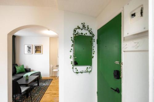 a green door in a living room with a green mirror at Quiet & Walkable - Stampede, BMO, Nightlife & Eats in Calgary