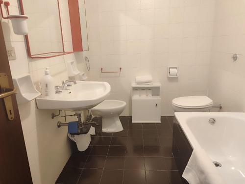 a white bathroom with a sink and a toilet at We ski Matese in San Massimo