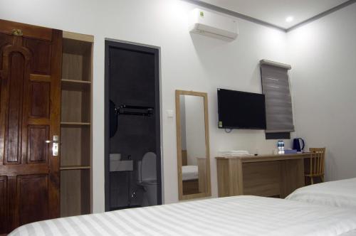 a bedroom with a bed and a tv and a mirror at Hotel88 in Ấp Bình Hưng