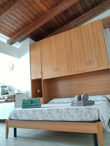 a bedroom with a large bed with wooden cabinets at Dimora al parco in Domusnovas