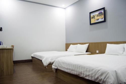 a room with two beds and a picture on the wall at Hotel88 in Ấp Bình Hưng