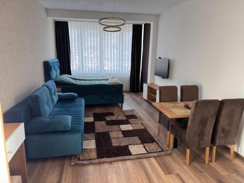 a living room with a blue couch and a table at Mecks apartmani in Novi Pazar