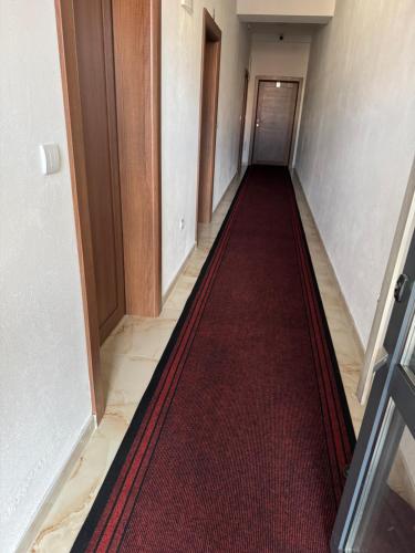 a hallway with a red carpet and a door at Mecks apartmani in Novi Pazar
