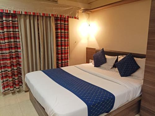 a bedroom with a bed with blue and white pillows at Tejas inn in Pune