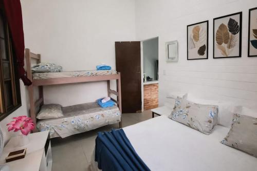 a room with two beds and a bunk bed at Pouso Ravenala - Refúgio do viajante in Paraty