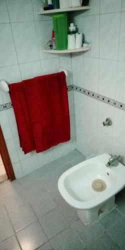 a bathroom with a red towel and a toilet at Beachside Vacation House in Ras al Khaimah
