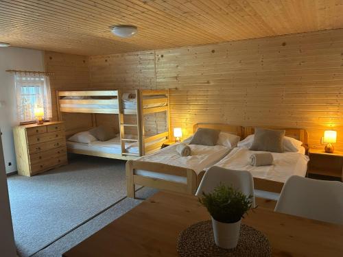 a bedroom with two bunk beds and a table at Apartmány u Pálavy in Přítluky
