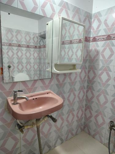 a bathroom with a pink sink and a mirror at The Rest Nest in Gorakhpur