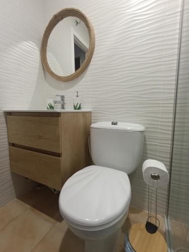 a bathroom with a toilet and a sink and a mirror at azahar playa apartmento in Mazarrón