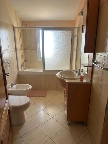 a bathroom with two sinks and a toilet and a window at The House of Passos in Ponta do Sol