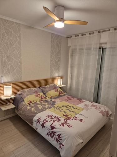 une chambre avec un lit et un ventilateur de plafond dans l'établissement Colbert 2, à Cambo-les-Bains
