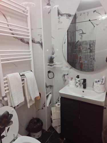 a white bathroom with a sink and a mirror at Apartment Zona 0 Tulcea in Tulcea