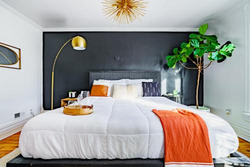 a bedroom with a large white bed with a black wall at Jungle House Luxury Homes - Columbus Downtown Short North - Steps to Convention Center & Nationwide Arena - Sleeps up to 11 - Free Parking - Over 5,800 Five Stars in Columbus