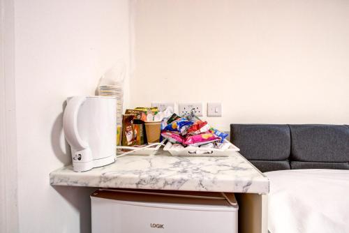 a table with a microwave on it next to a bed at Royal London Hotel in London