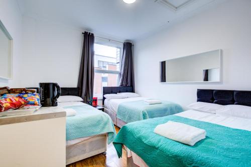 a room with two beds and a mirror at Royal London Hotel in London