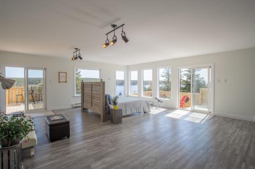 a large white bedroom with a bed and large windows at Whale House Guest House in Mobile