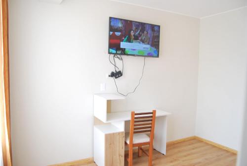 a room with a desk and a tv on a wall at Kymeron Hotel in Juliaca