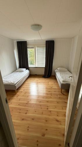 a room with two beds and a wooden floor at Ribe Villa in Stockholm