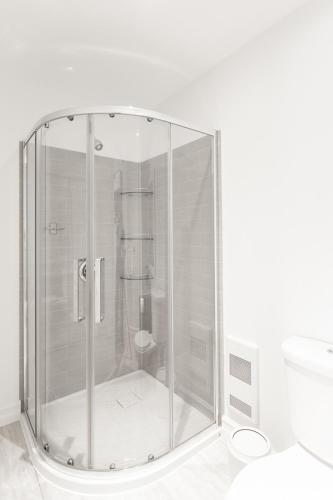 a glass shower with a toilet in a bathroom at Whale House Guest House in Mobile