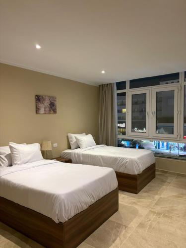 a hotel room with two beds and a window at The Fit Stop Hostel in Hurghada